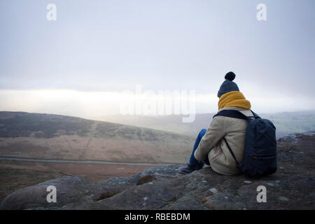Young woman takes a break during a hike up Stanage Edge, Derbyshire, Peak District, England Stock Photo