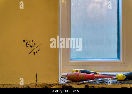 Builders calculations written on wall while building work is carried out. Stock Photo