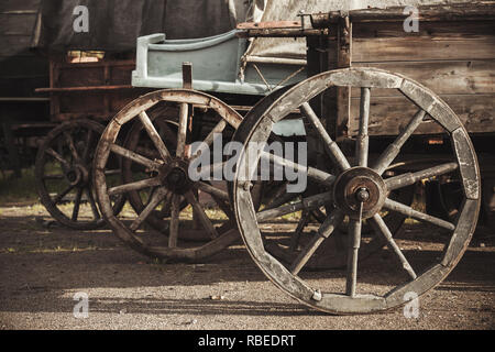 Wheels of vintage wooden wagons standing on rural road Stock Photo