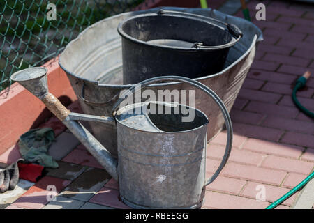 Watering buckets in the garden. Gardening concept image with metal bucket for water Stock Photo
