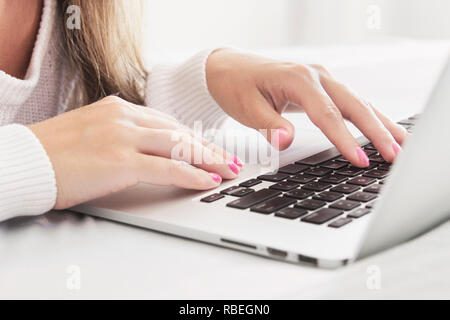 Close up of Womans Hands Typing with Laptop in Cozy Bed Shallow DOF Stock Photo