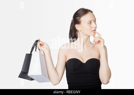 Black Friday Sales Concept with Young Woman and White Black Bags on Light Background Stock Photo