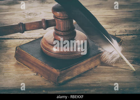 Law gavel or judge mallet and feather pen on a wooden desk Stock Photo