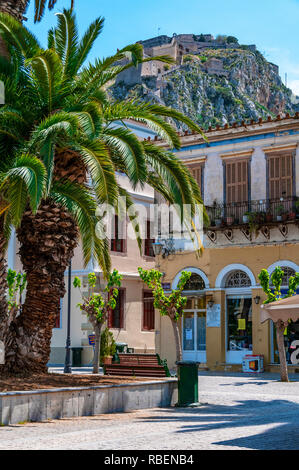 Typical Greek street with a view of Palamidi Castle or Fortress  in the town of Nafplion or Nafplio, Peloponnese, Greece Stock Photo