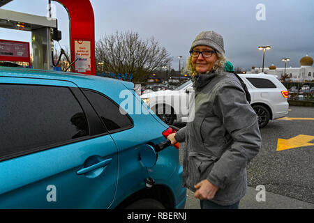 Woman pumping gas Stock Photo - Alamy