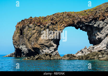 Punta Perciato natural volcanic arch formed from lava on the crystal clear tyrrhenian sea, Pollara, Salina. Aeolian Islands Archipelago, Sicily, Italy Stock Photo