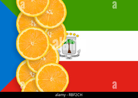 Equatorial Guinea flag and vertical row of orange citrus fruit slices. Concept of growing as well as import and export of citrus fruits Stock Photo