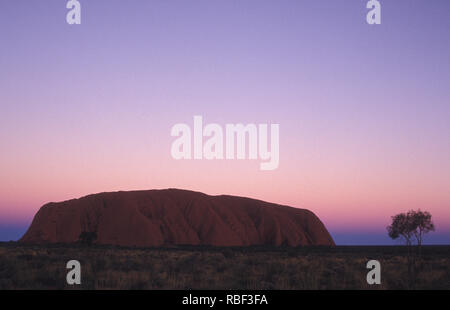 Uluru also known as Ayers Rock and officially gazetted as 'Uluru / Ayers Rock' is a large sandstone rock formation in the southern part of the NT. Stock Photo