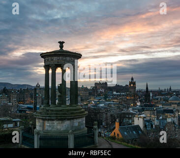 Edinburgh, Scotland, United Kingdom, 9th January 2019. UK Weather: Silhouette of the Douglas Stewart monument on Calton Hill overlooking the city centre skyline at sunset with Balmoral clock tower lit up, church spires and Edinburgh Castle Stock Photo