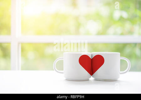 Mugs cups of coffee or tea for two lovers honeymoon wedding morning in coffee shop with green nature in background. Copy space with white wooden table Stock Photo