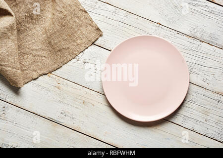 Empty plate and towel over wooden table background. Stock Photo