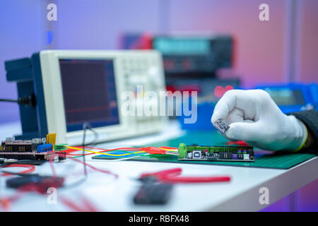 Development of electronic devices in the modern electronics laboratory, on a table, microprocessor oscilloscope and multimeter Stock Photo
