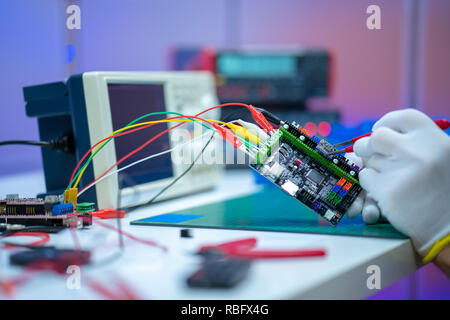 Development of electronic devices in the modern electronics laboratory, on a table, microprocessor oscilloscope and multimeter Stock Photo