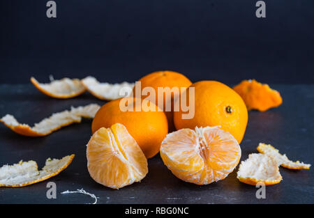 Mandarins and carvings on a dark background Stock Photo