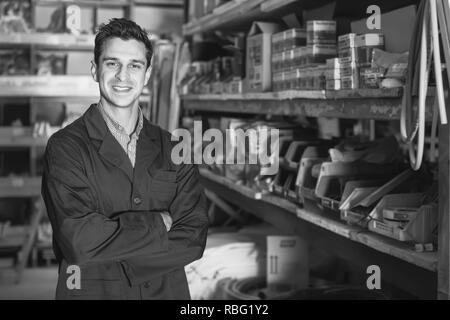 Portrait of cheerful working male in uniform on his workplace in building store. Stock Photo