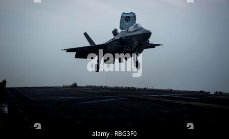ARABIAN GULF – An F-35B Lightning II with Marine Fighter Attack Squadron 211, 13th Marine Expeditionary Unit (MEU), engages its landing gear to land aboard the Wasp-class amphibious assault ship USS Essex (LHD 2), Dec. 4, 2018. The Essex is the flagship for the Essex Amphibious Ready Group and, with the embarked 13th MEU, is deployed to the U.S. 5th Fleet area of operations in support of naval operations to ensure maritime stability and security in the Central Region, connecting the Mediterranean and the Pacific through the western Indian Ocean and three strategic choke points. (U.S. Marine Co Stock Photo