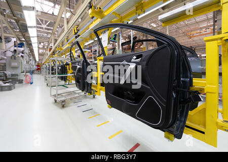 car door on conveyor. Robotic equipment makes Assembly of car. Modern car Assembly at factory Stock Photo