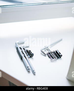 Tools on the windowsill to adjust the plastic window. Thin devices Stock Photo
