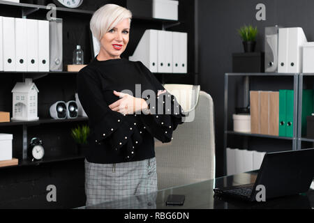 young girl stands near computer Desk in a stylish business office Stock Photo