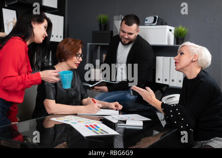 Office workers discuss their project over Cup of tea Stock Photo