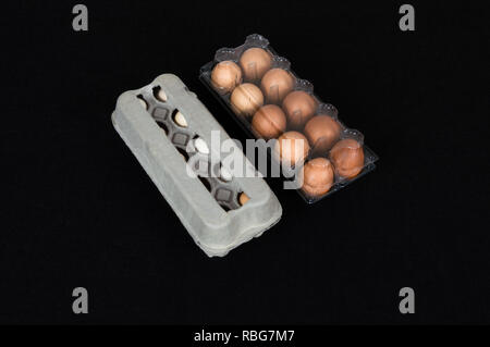 Twenty chicken eggs in carton and plastic boxes, isolated on black felt background. Stock Photo