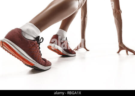Portrait of young sporty woman at starting block of race isolated over white studio background. The sprinter, jogger, exercise, workout, fitness, training, jogging concept. Profile Stock Photo