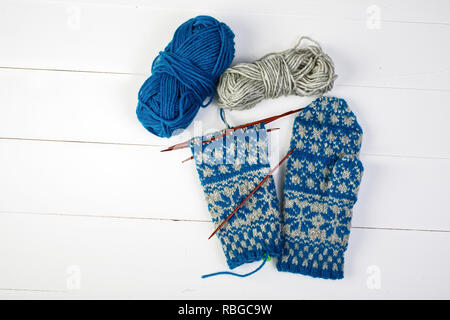 A pair of unfinished Scandinavian inspired stranded colorwork knitted mittens. Stock Photo