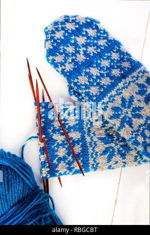 A pair of unfinished Scandinavian inspired stranded colorwork knitted mittens. Stock Photo