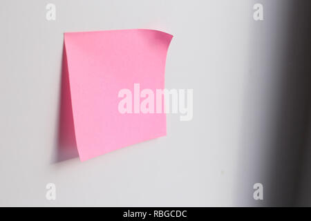 Pink sticky note with copy space on blue background Stock Photo
