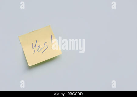 text Yes on yellow paper sticker on the blue background, Success and Goal Concept Stock Photo