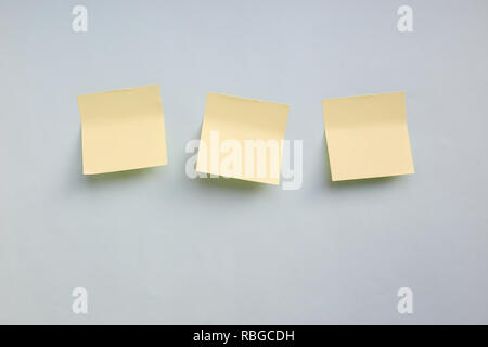 Three yellow paper stickers note with copy space on light blue background Stock Photo