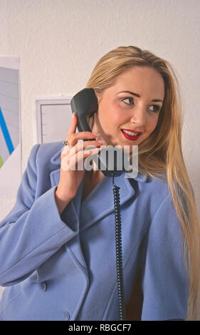 Young woman talking on landline telephone Stock Photo