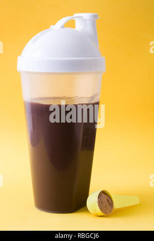 Chocolate protein shake on yellow background. Stock Photo