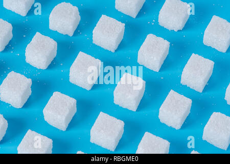 Pattern of sugar refined cubes with shadows on a blue background. The concept of harmful ingredient for confectionery Stock Photo
