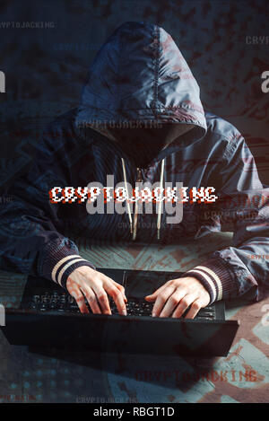 An anonymous hacker without a face is trying to steal cryptocurrency using a computer. Fraud and deception at Cryptojacking Stock Photo