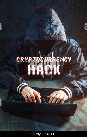 An anonymous hacker without a face is trying to steal cryptocurrency using a computer. Fraud and deception at Cryptojacking Stock Photo