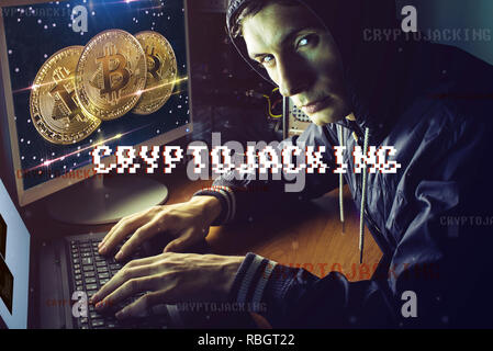 A hacker with a face is trying to steal cryptocurrency using a computer. Fraud and deception at Cryptojacking Stock Photo