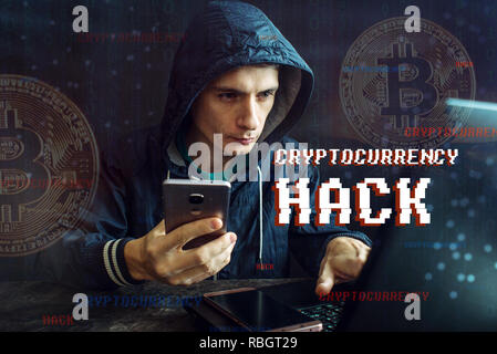 A hacker with a face is trying to steal cryptocurrency using a computer. Fraud and deception at Cryptojacking Stock Photo