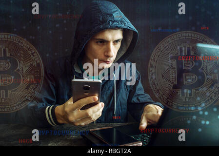 A hacker with a face is trying to steal cryptocurrency using a computer. Fraud and deception at Cryptojacking Stock Photo