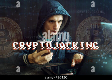 A hacker with a face is trying to steal cryptocurrency using a computer. Fraud and deception at Cryptojacking Stock Photo