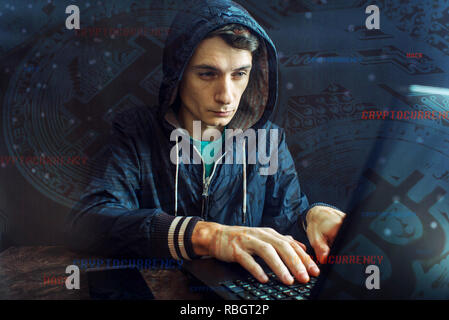 A hacker with a face is trying to steal cryptocurrency using a computer. Fraud and deception at Cryptojacking Stock Photo