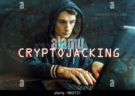 A hacker with a face is trying to steal cryptocurrency using a computer. Fraud and deception at Cryptojacking Stock Photo