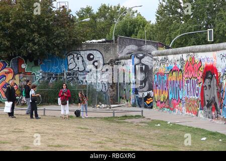 BERLIN, GERMANY - AUGUST 26, 2014: People visit the Berlin Wall (Berliner Mauer). Iconic iron curtain border divided Berlin in years 1961-1989. Stock Photo