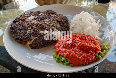 Traditional serbian and balkan dish Pljeskavica with sauce in Maribor,Slovenia Stock Photo