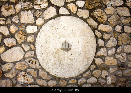 White Cemented Round Shape with Hole in Center. Big Circle Design in Middle of Stone Paved Surface. Dirty Stains and Smears on Rocks. Design Ideas for Stock Photo