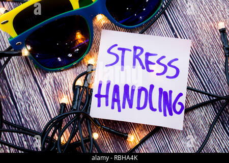 Scattered Lighted Tiny LED Stringlight on Wooden Surface. Two Colorful Sunglasses with Light Reflecting. Handwritten Message on Handling Stress Manage Stock Photo