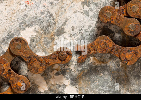 Weakest link in a strong steel rusty roller chain is broken snapped leading to mechanical failure, breakdown, loss of productivity Stock Photo