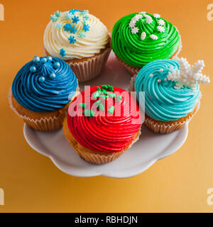 Christmas and winter cupcakes on the cakestand and gold background Stock Photo