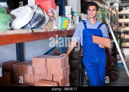 Craftsman is choosing tiles in the building store. Stock Photo
