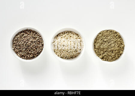 Organic hemp whole seeds, hulled seeds and protein powder in bowls on a white background Stock Photo